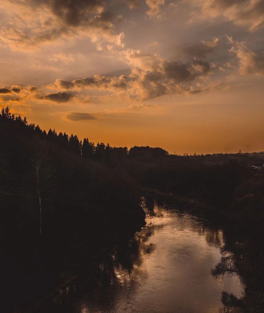 A quiet wooded river at sunset