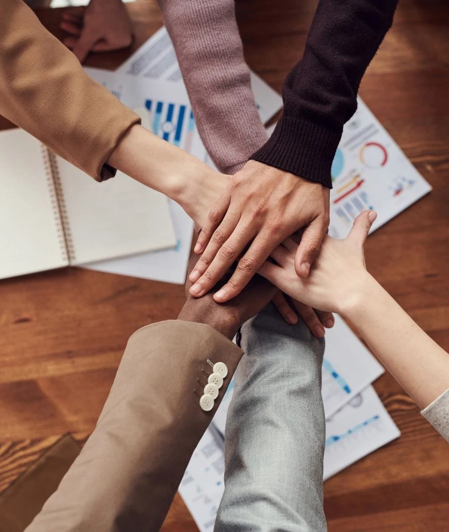 Hands joined above a table during a team activity