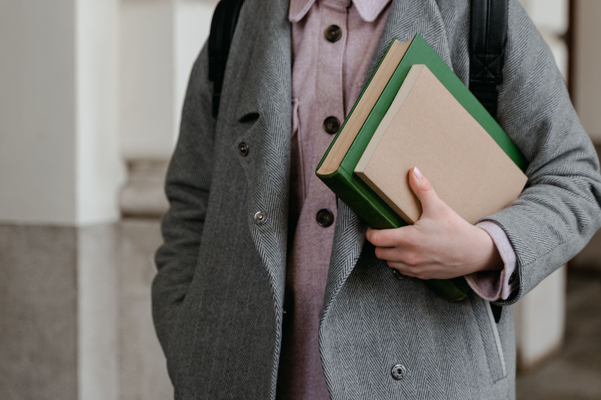 A person holding a stack of books